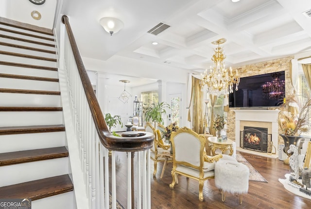 living room featuring beam ceiling, hardwood / wood-style floors, a chandelier, and coffered ceiling