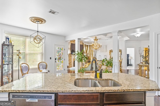 kitchen with decorative light fixtures, stainless steel dishwasher, sink, light stone counters, and ornate columns