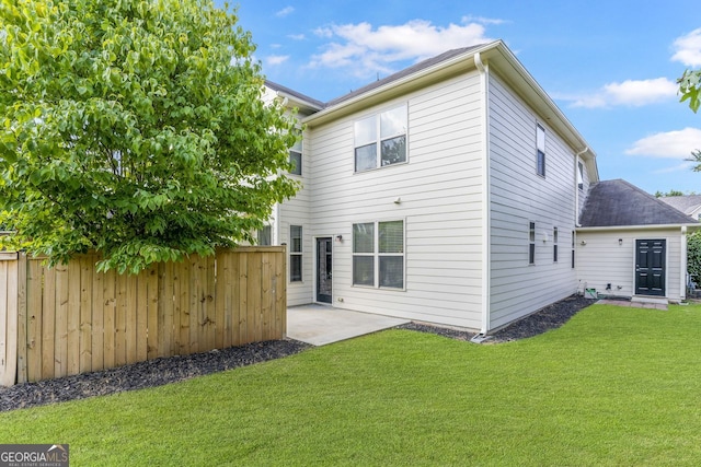 rear view of property with a patio and a lawn