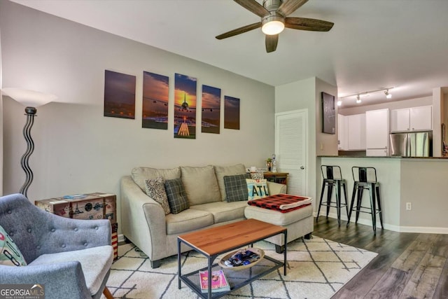 living room featuring ceiling fan, hardwood / wood-style floors, and rail lighting