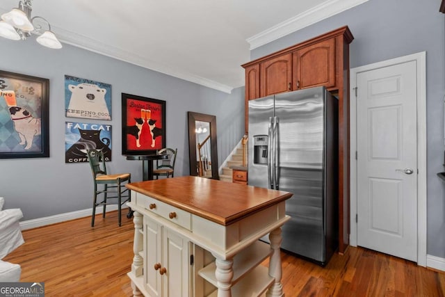 dining room with a wealth of natural light, light hardwood / wood-style floors, a notable chandelier, and ornamental molding