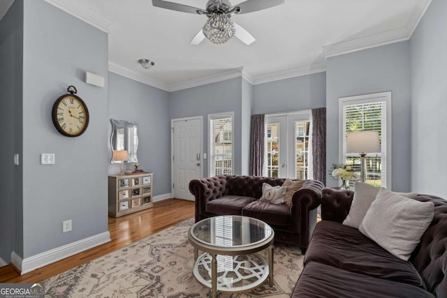 living room featuring hardwood / wood-style floors, ceiling fan, ornamental molding, and french doors