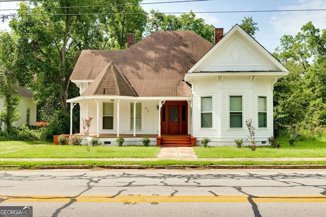 victorian home with a front lawn