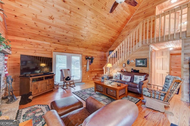 living room featuring high vaulted ceiling, wooden ceiling, ceiling fan, wood-type flooring, and wood walls