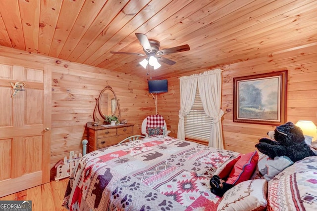 bedroom with ceiling fan, wood walls, wood ceiling, and wood-type flooring