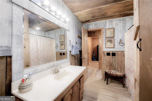 bathroom with wood ceiling, wooden walls, wood-type flooring, and vanity