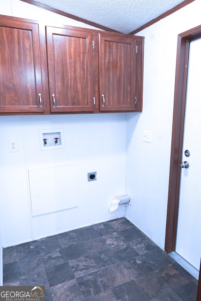 clothes washing area featuring hookup for an electric dryer, cabinets, a textured ceiling, and washer hookup