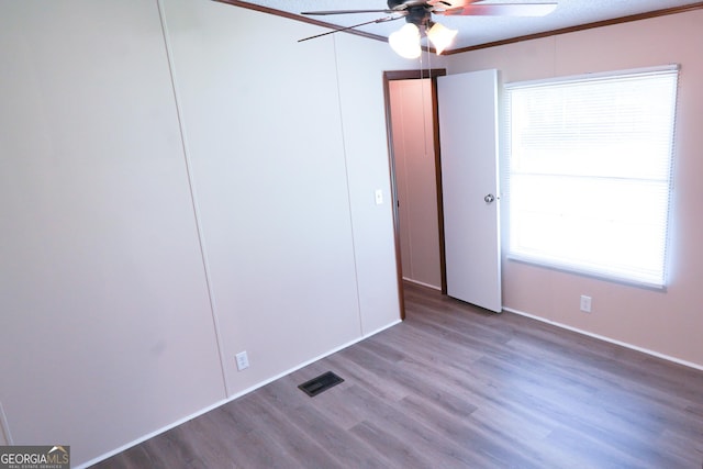 unfurnished bedroom with ceiling fan, hardwood / wood-style floors, crown molding, and a textured ceiling