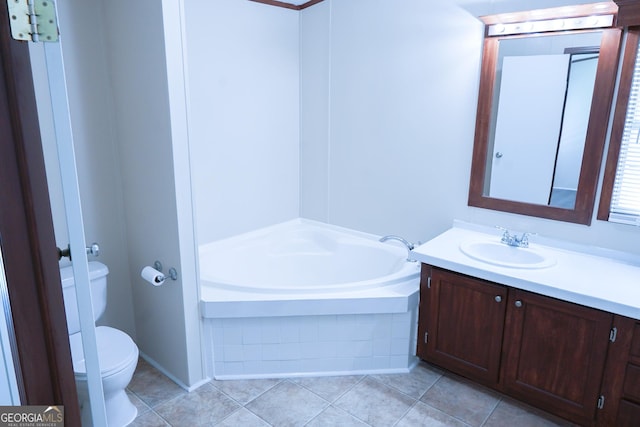 bathroom with vanity, tiled bath, and toilet