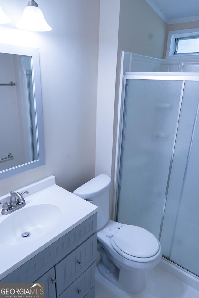 bathroom featuring vanity, toilet, ornamental molding, and walk in shower