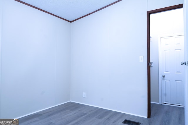 empty room with a textured ceiling and dark hardwood / wood-style floors