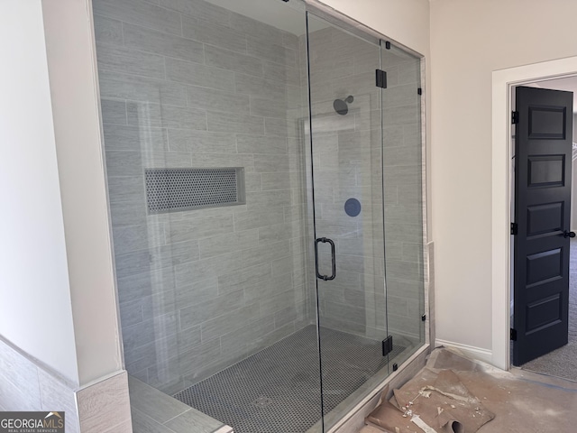 full bath with a stall shower and baseboards