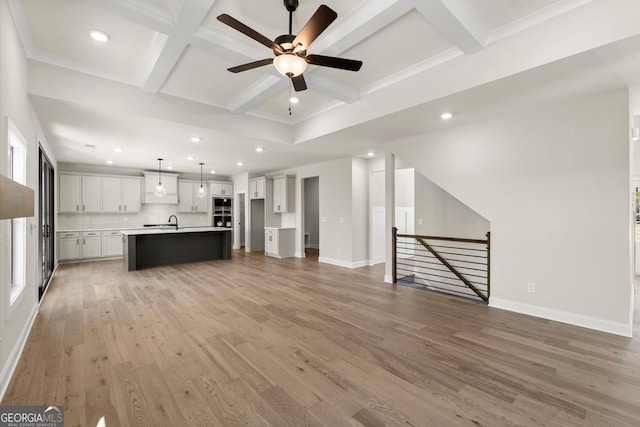 unfurnished living room with recessed lighting, coffered ceiling, baseboards, light wood-type flooring, and beam ceiling