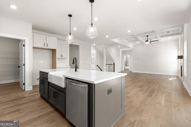 kitchen featuring coffered ceiling, a sink, light wood finished floors, and stainless steel dishwasher