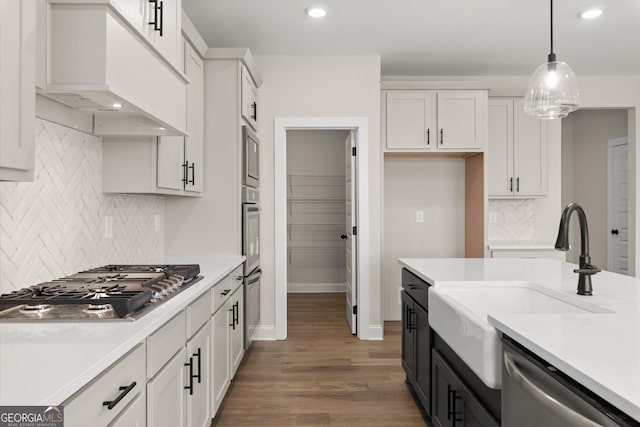 kitchen with premium range hood, white cabinetry, stainless steel appliances, and light countertops