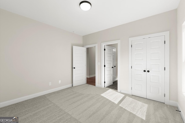 unfurnished bedroom featuring a closet, carpet, and baseboards