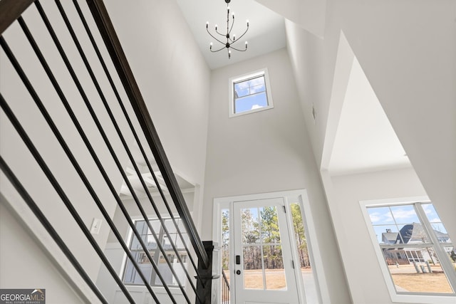 entrance foyer with a high ceiling, stairway, and a notable chandelier