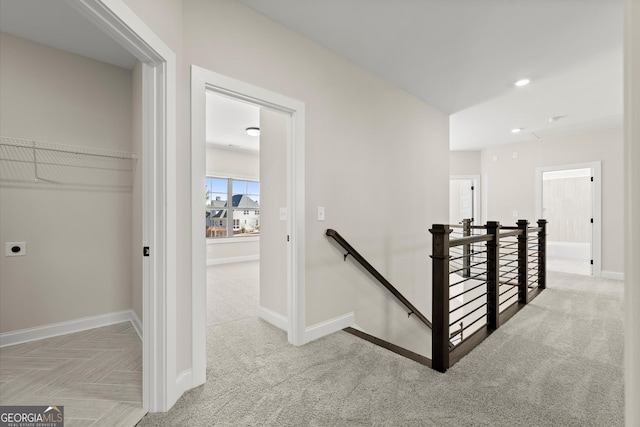 hall featuring carpet, an upstairs landing, and baseboards