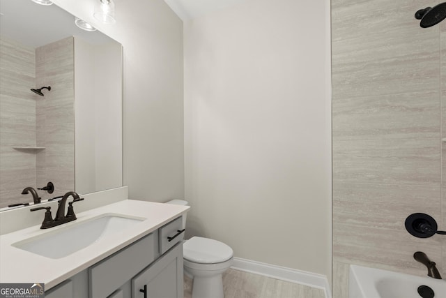 full bathroom featuring toilet, wood finished floors, vanity, baseboards, and  shower combination