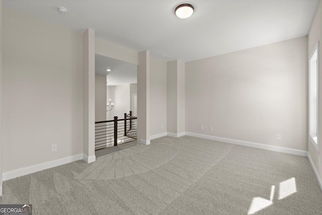 empty room featuring baseboards and carpet flooring