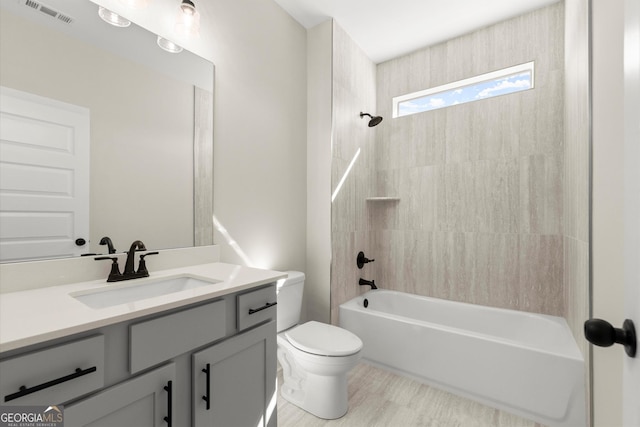 bathroom featuring toilet, tub / shower combination, vanity, and visible vents