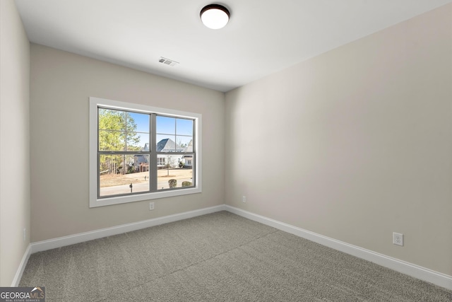 unfurnished room with carpet flooring, visible vents, and baseboards