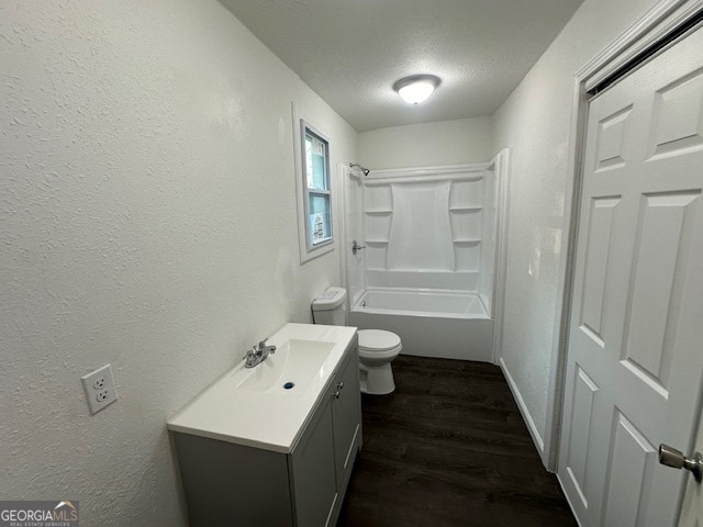 full bathroom with a textured ceiling,  shower combination, hardwood / wood-style flooring, toilet, and vanity