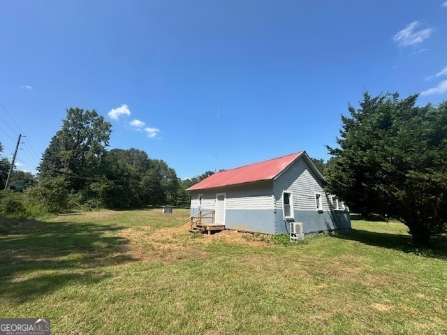 view of side of home with a yard