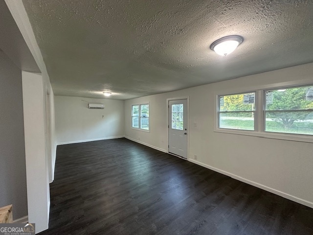 interior space featuring dark hardwood / wood-style floors, a wealth of natural light, and a textured ceiling