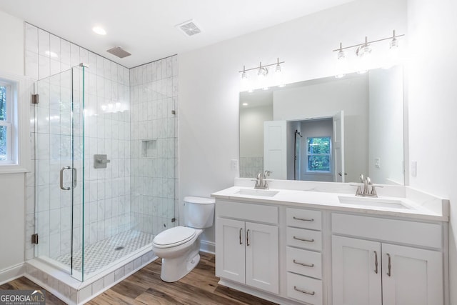 bathroom with vanity, toilet, hardwood / wood-style floors, and an enclosed shower