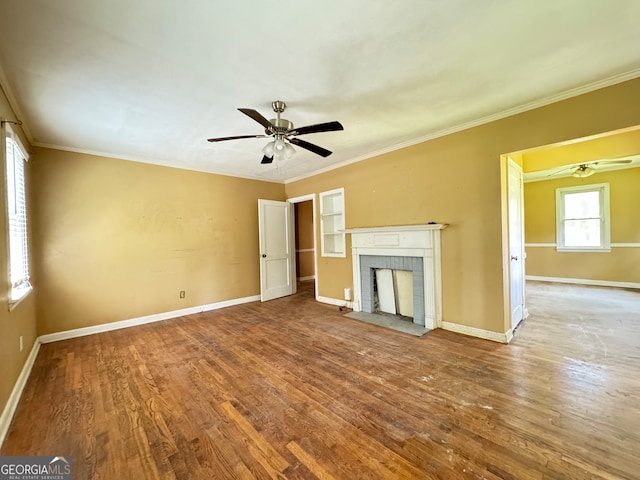 unfurnished living room featuring a brick fireplace, ceiling fan, crown molding, and wood-type flooring