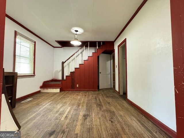 interior space featuring wood-type flooring and crown molding