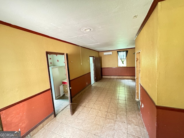 empty room featuring crown molding, a textured ceiling, and tile patterned flooring