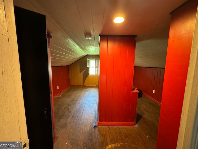 bonus room with vaulted ceiling, hardwood / wood-style flooring, and wood walls