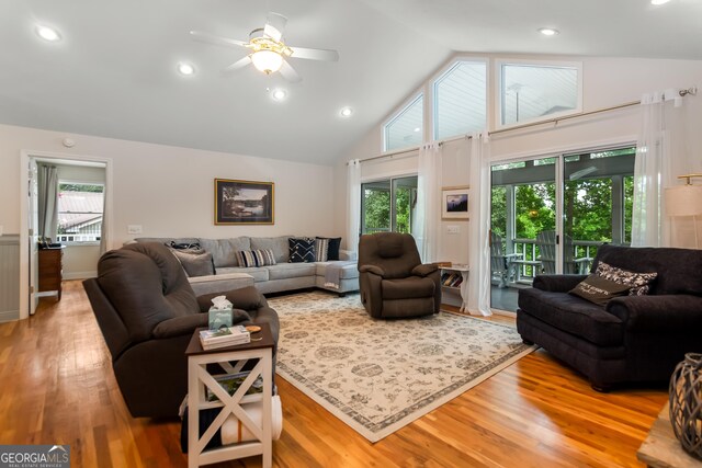 living room featuring hardwood / wood-style flooring, ceiling fan, and high vaulted ceiling