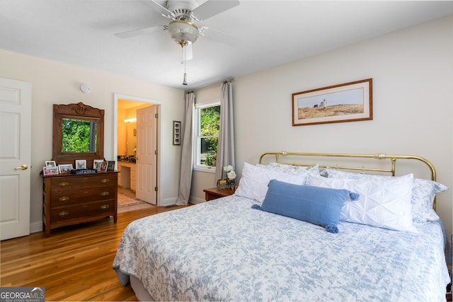 bedroom with ceiling fan, wood-type flooring, and ensuite bathroom