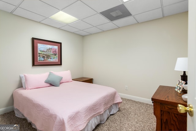 carpeted bedroom featuring a drop ceiling