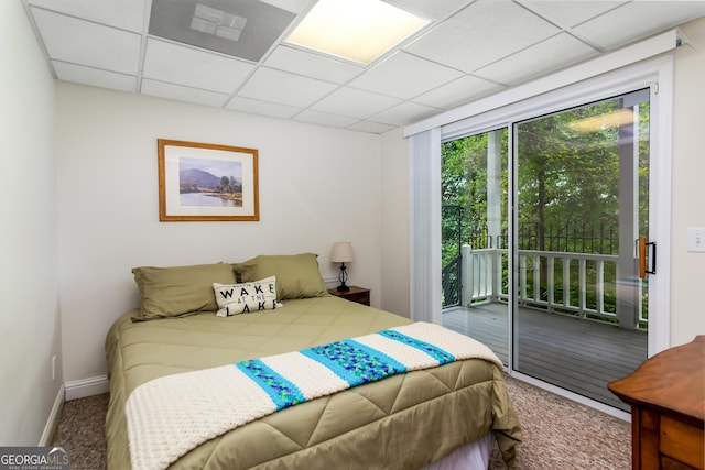 carpeted bedroom featuring a drop ceiling