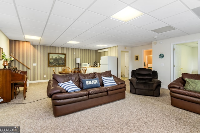 carpeted living room featuring a drop ceiling