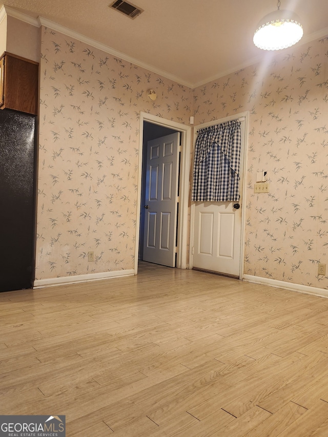 spare room featuring hardwood / wood-style flooring and ornamental molding