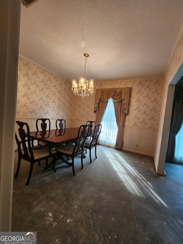 unfurnished dining area with concrete floors, a textured ceiling, and an inviting chandelier