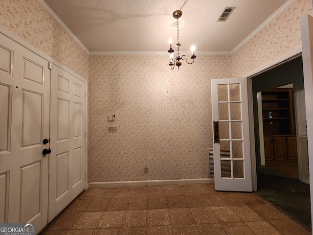 empty room with a notable chandelier, a textured ceiling, ornamental molding, and tile patterned flooring