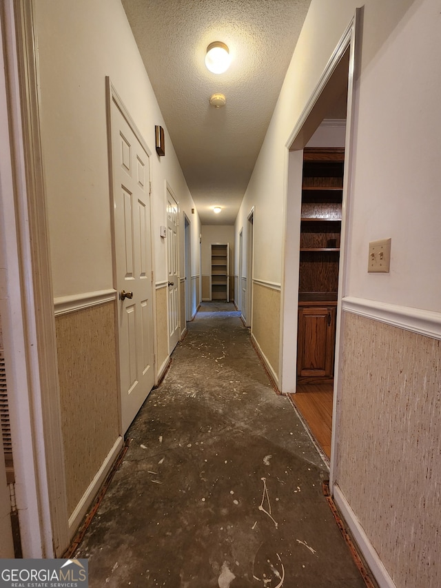 hallway featuring a textured ceiling and dark hardwood / wood-style floors