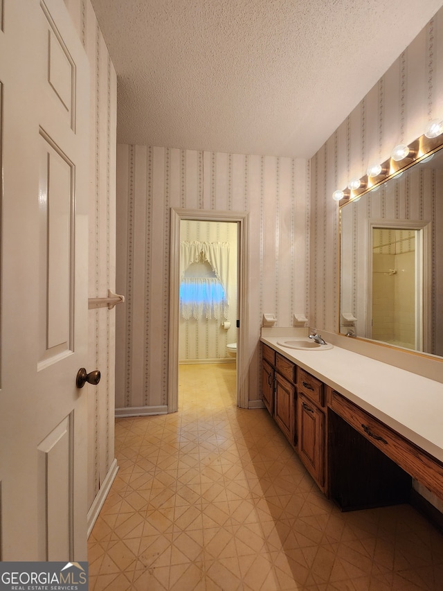 bathroom with tile patterned floors, a textured ceiling, and vanity