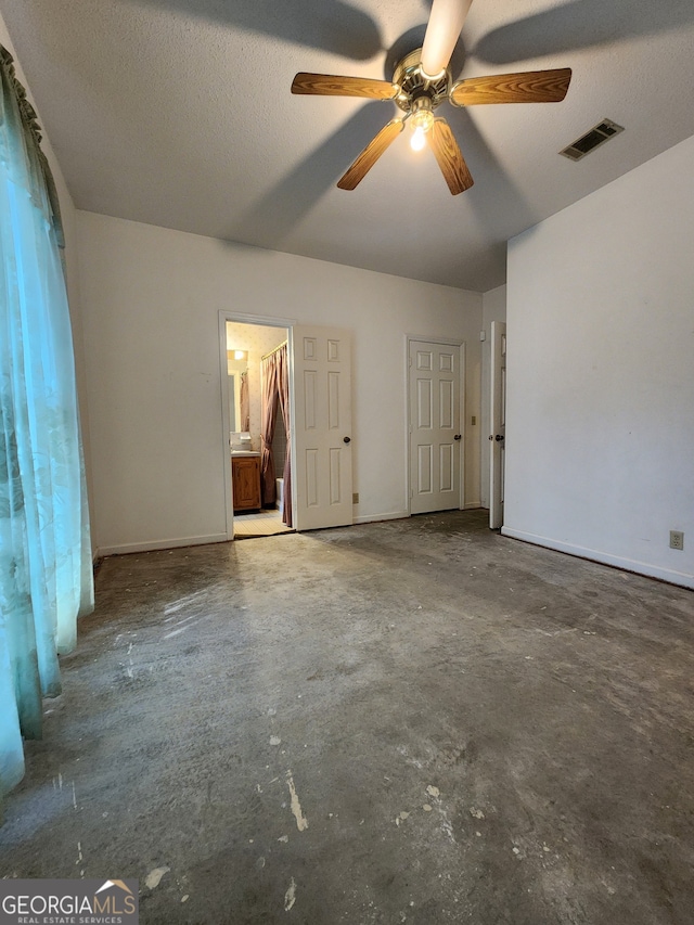 unfurnished bedroom with a textured ceiling, concrete flooring, and ceiling fan