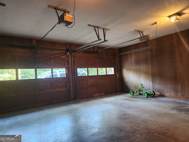 garage with a garage door opener and wood walls