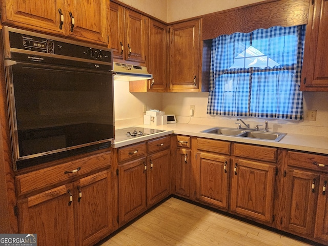 kitchen featuring sink, black appliances, and light hardwood / wood-style floors