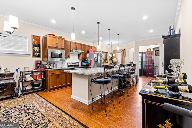 kitchen featuring stainless steel appliances, crown molding, a kitchen breakfast bar, and light hardwood / wood-style flooring