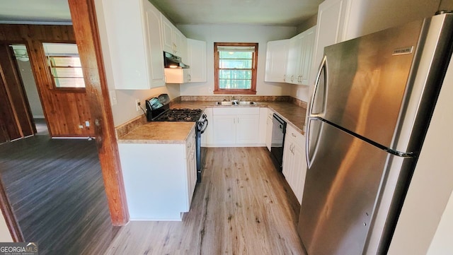 kitchen featuring stainless steel fridge, range with gas cooktop, white cabinets, and light wood-type flooring