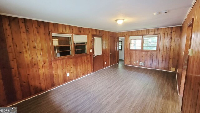 empty room with wooden walls and dark hardwood / wood-style flooring